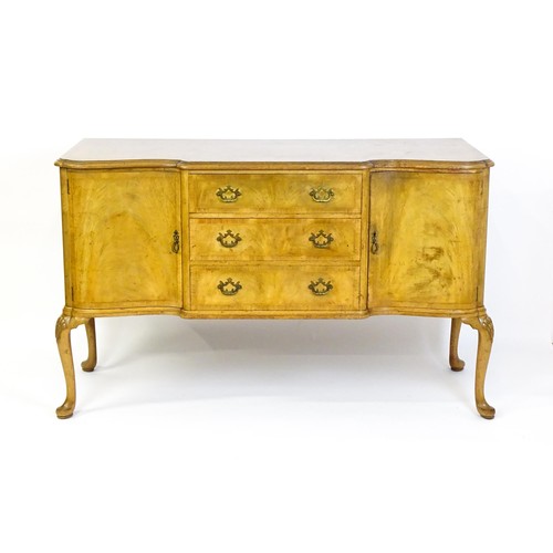 617 - An early / mid 20thC Waring & Gillows walnut sideboard with a serpentine shaped front and a crossban... 