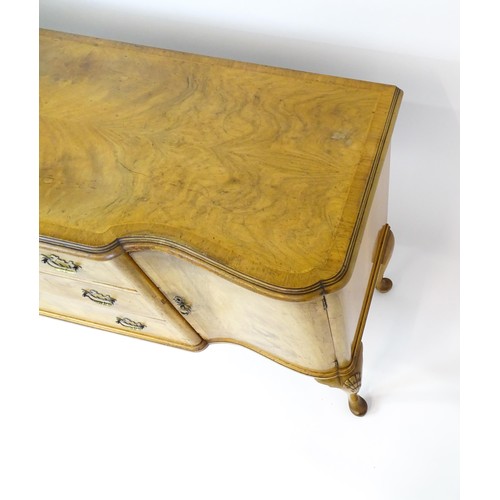 617 - An early / mid 20thC Waring & Gillows walnut sideboard with a serpentine shaped front and a crossban... 