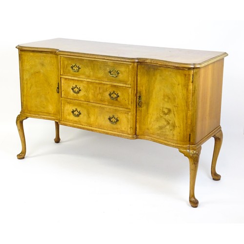 617 - An early / mid 20thC Waring & Gillows walnut sideboard with a serpentine shaped front and a crossban... 
