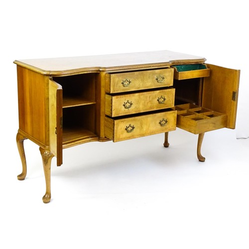 617 - An early / mid 20thC Waring & Gillows walnut sideboard with a serpentine shaped front and a crossban... 