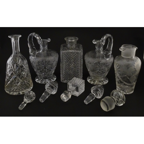 628 - A quantity of assorted cut glass decanters, claret jugs, etc. Largest approx. 11 1/4
