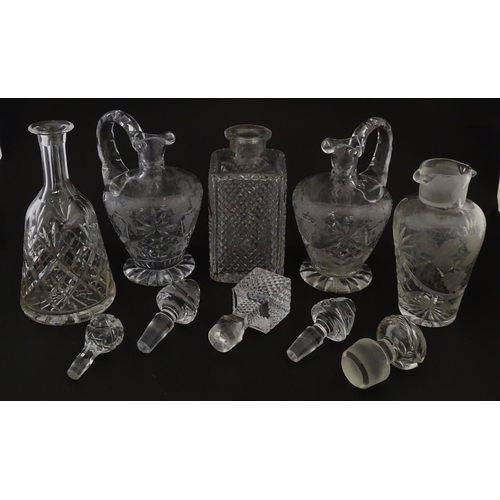 628 - A quantity of assorted cut glass decanters, claret jugs, etc. Largest approx. 11 1/4