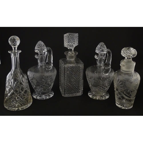628 - A quantity of assorted cut glass decanters, claret jugs, etc. Largest approx. 11 1/4