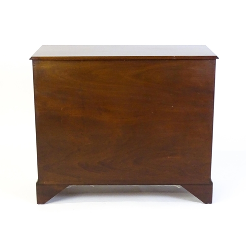 635 - A mahogany cabinet with a moulded top above two short drawers and two panelled cupboard, the cabinet... 