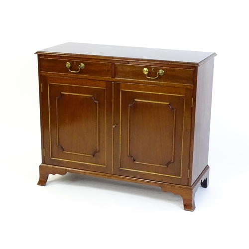 635 - A mahogany cabinet with a moulded top above two short drawers and two panelled cupboard, the cabinet... 