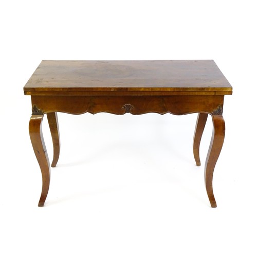 639 - An early 20thC mahogany tea table of large proportions, the hinged rectangular top above a shell car... 