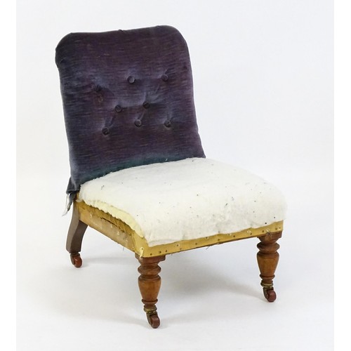 641 - An early 20thC nursing chair with a deep buttoned backrest and sprung seat raised on turned tapering... 