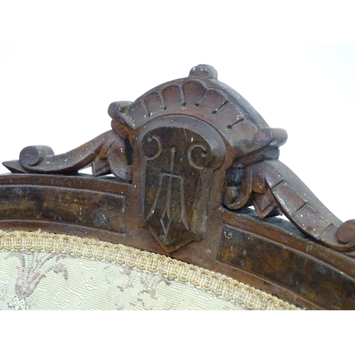 643 - An early 20thC rocking chair with carved cresting rail above a chamfered frame, with upholstered bac... 