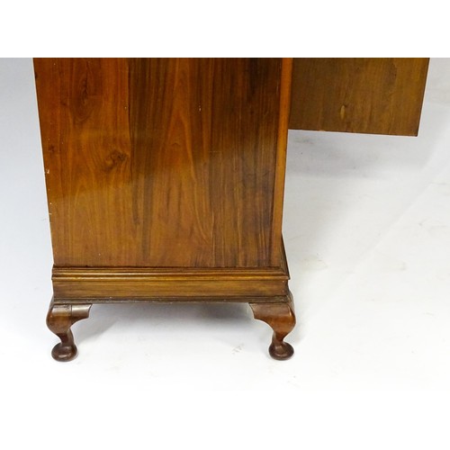 645 - An Art Deco style walnut wardrobe with a shaped cornice above a single panelled door raised on a det... 