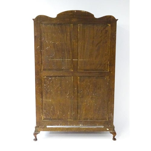 645 - An Art Deco style walnut wardrobe with a shaped cornice above a single panelled door raised on a det... 