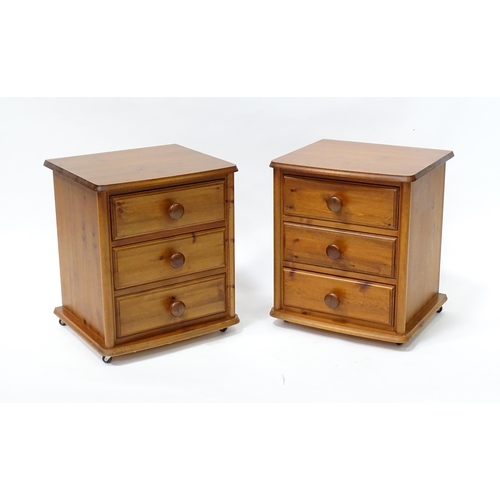 647 - A pair of pine bedside cabinets, each with three drawers with turned wooden handles. 18