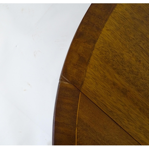 655 - A mid / late 20thC mahogany drop flap dining table, having a crossbanded and reeded rotating top rai... 