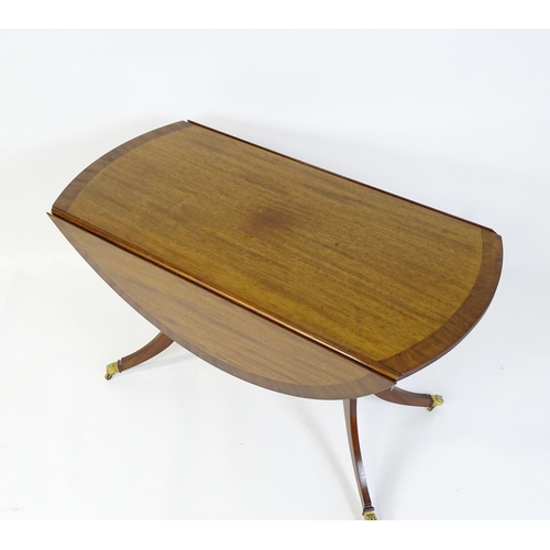 655 - A mid / late 20thC mahogany drop flap dining table, having a crossbanded and reeded rotating top rai... 
