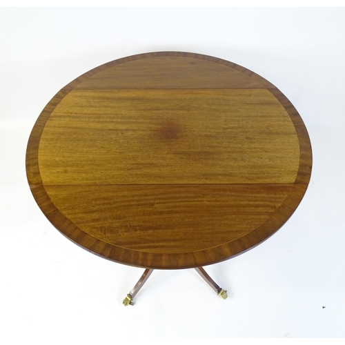 655 - A mid / late 20thC mahogany drop flap dining table, having a crossbanded and reeded rotating top rai... 