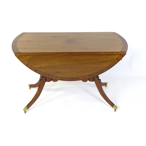 655 - A mid / late 20thC mahogany drop flap dining table, having a crossbanded and reeded rotating top rai... 