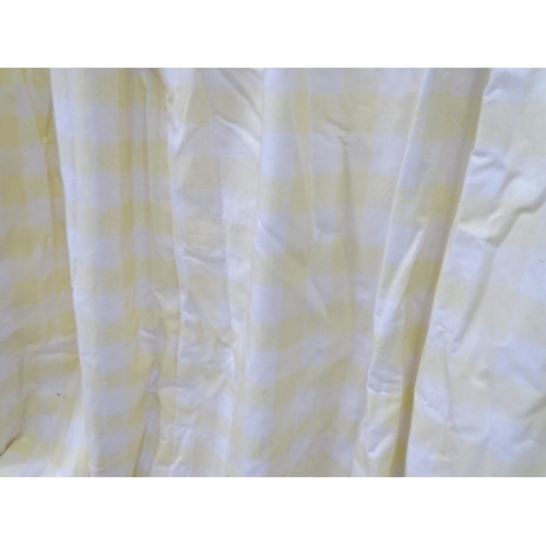 657 - A pair of curtains decorated in a yellow and white check pattern with bow detail. Together with a ma... 