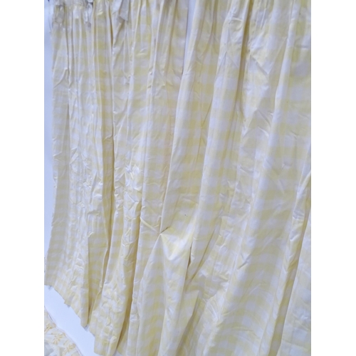 657 - A pair of curtains decorated in a yellow and white check pattern with bow detail. Together with a ma... 