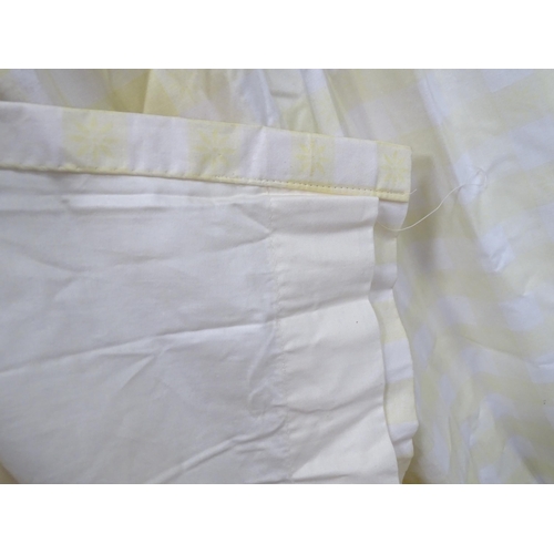 657 - A pair of curtains decorated in a yellow and white check pattern with bow detail. Together with a ma... 