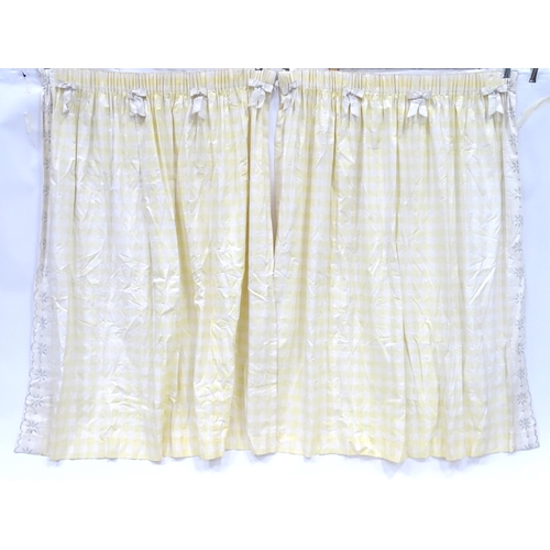 657 - A pair of curtains decorated in a yellow and white check pattern with bow detail. Together with a ma... 