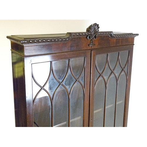 664 - An early 20thC mahogany bureau bookcase with a carved cornice above two astragal glazed doors and a ... 