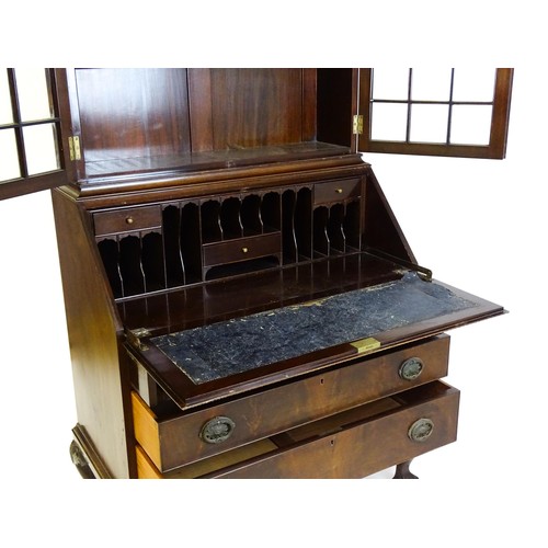 664 - An early 20thC mahogany bureau bookcase with a carved cornice above two astragal glazed doors and a ... 