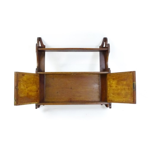 668 - An early 20thC wall hanging mahogany cabinet with two mirrored doors. 23 1/2