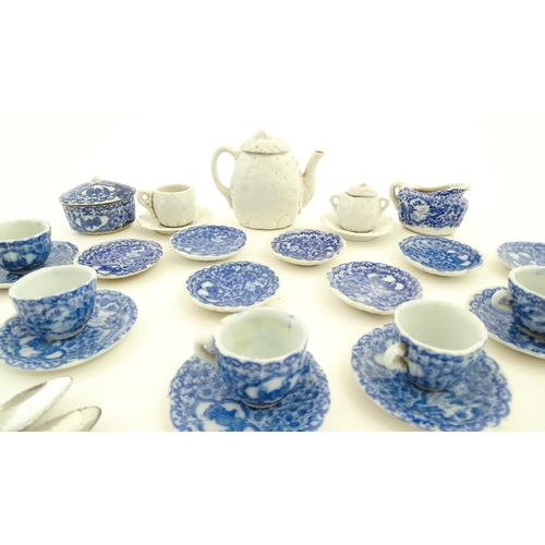 712 - A quantity of blue and white miniature tea wares to include milk jug, sugar bowl, cups and saucers. ... 