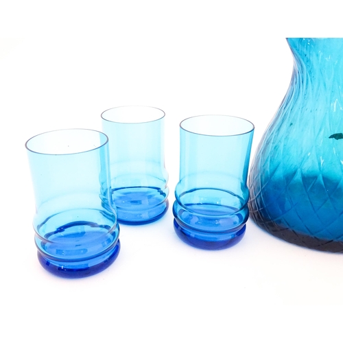 725 - A quantity of turquoise glass to include jugs, glasses etc. Largest jug approx. 7 3/4