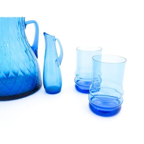 725 - A quantity of turquoise glass to include jugs, glasses etc. Largest jug approx. 7 3/4