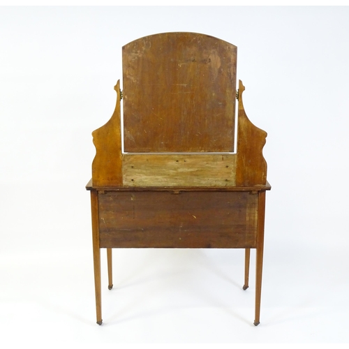 740 - An early 20thC mahogany dressing table with a shaped upstand, shelf and arched mirror. The top havin... 