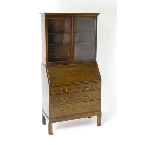 761 - A mid 20hC mahogany bureau bookcase by Russell of Broadway. The bookcase with a moulded cornice abov... 