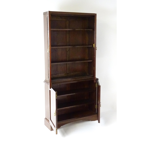 763 - An early / mid 20thC mahogany bookcase with stained and leaded glass panels above two panelled cupbo... 