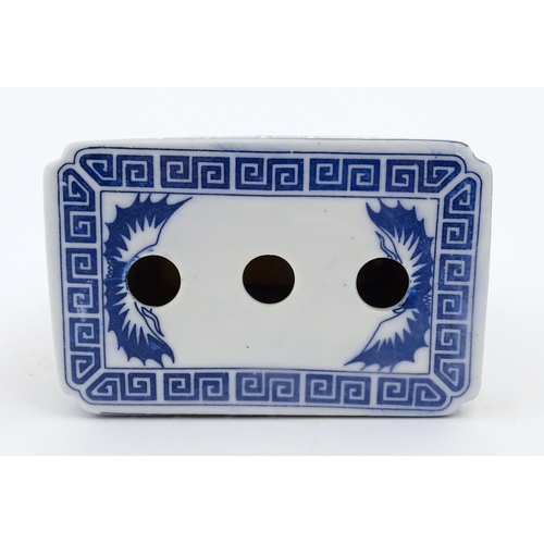 782 - A Chinese blue and white flower brick decorated with foo dogs within vignettes bordered by prunus fl... 