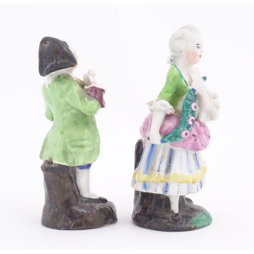 822 - Two Continental ceramic figures, depicting a Regency gentleman and a young lady. One indistinctly ma... 