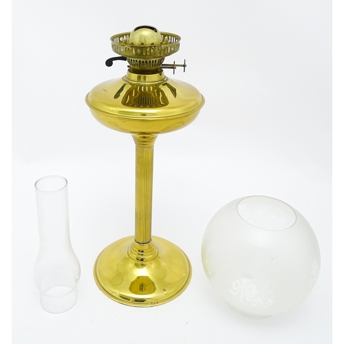 836 - A brass oil lamp with column detail and spherical shade. Approx. 28 1/2