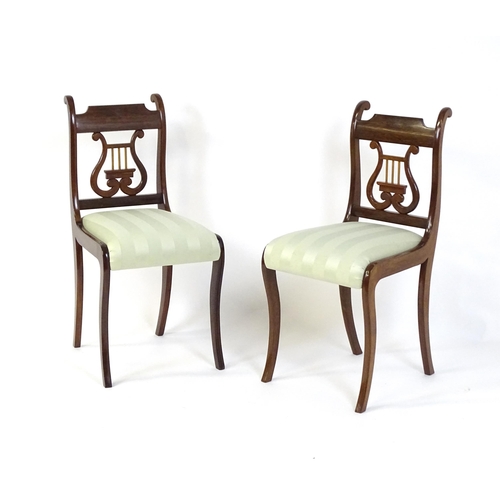 844 - A pair of mid  / late 20thC mahogany side chairs with lyre shaped back splats and raised on sabre le... 