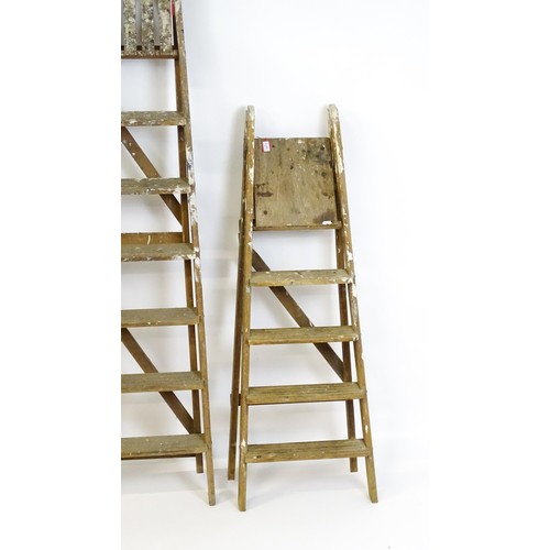 855 - Two A-frame platform ladders together with a straight ladder, the largest approx 82