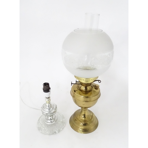 400 - A 20thC brass oil lamp. Together with a table lamp. Oil lamp approx. 20 1/2
