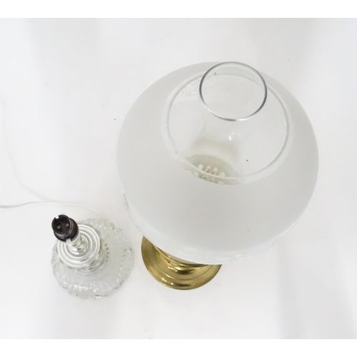 400 - A 20thC brass oil lamp. Together with a table lamp. Oil lamp approx. 20 1/2