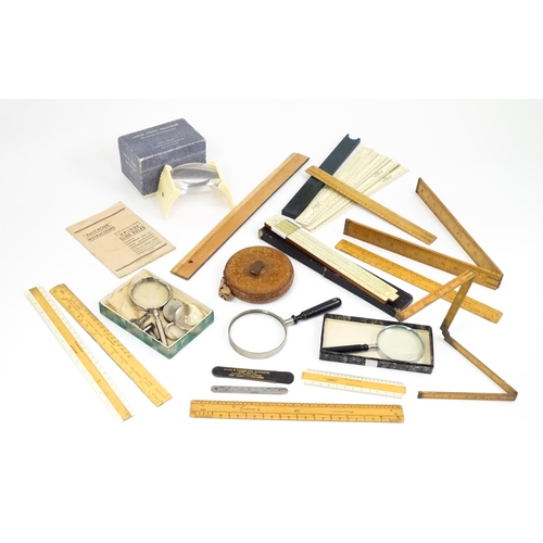 727 - A quantity of rules and rulers to include folding boxwood examples. Together with various magnifying... 