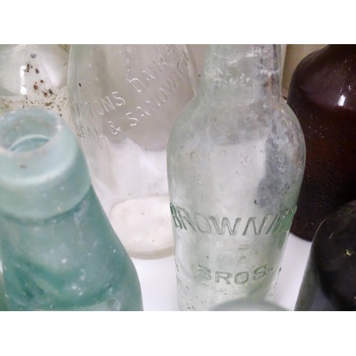 76 - A quantity of early to mid 20thC glass bottles, to include codd lemonade / soda bottles, brown glass... 