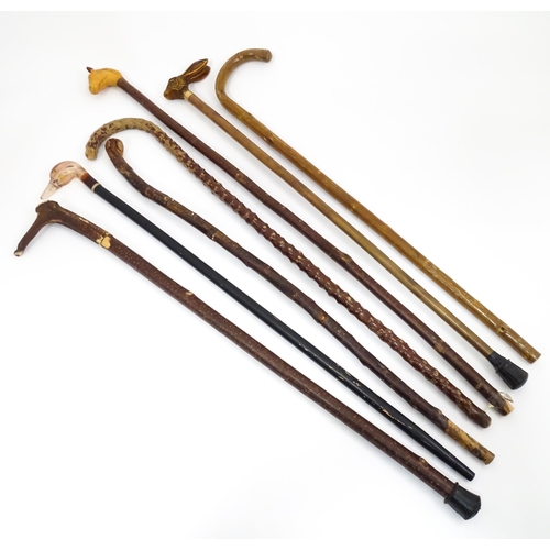 829 - A quantity of walking sticks / canes, comprising a hazel stick with antler handle and whistle tip, a... 