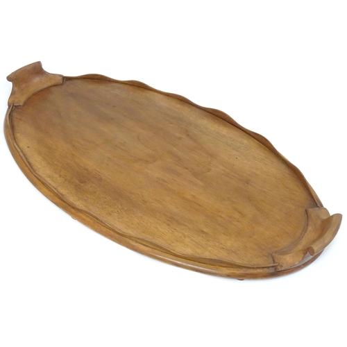 106 - A 20thC wooden tray of oval form with twin handles and lobed gallery. Approx. 27 1/2