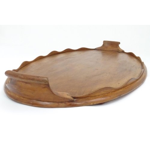 106 - A 20thC wooden tray of oval form with twin handles and lobed gallery. Approx. 27 1/2