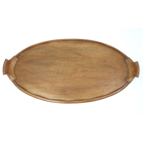 106 - A 20thC wooden tray of oval form with twin handles and lobed gallery. Approx. 27 1/2