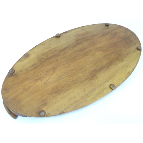 106 - A 20thC wooden tray of oval form with twin handles and lobed gallery. Approx. 27 1/2