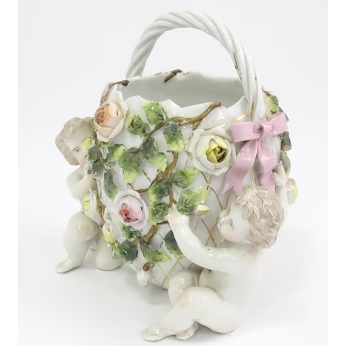 393 - A German porcelain basket with cherub and encrusted flower detail. Marked under with Sitzendorf styl... 