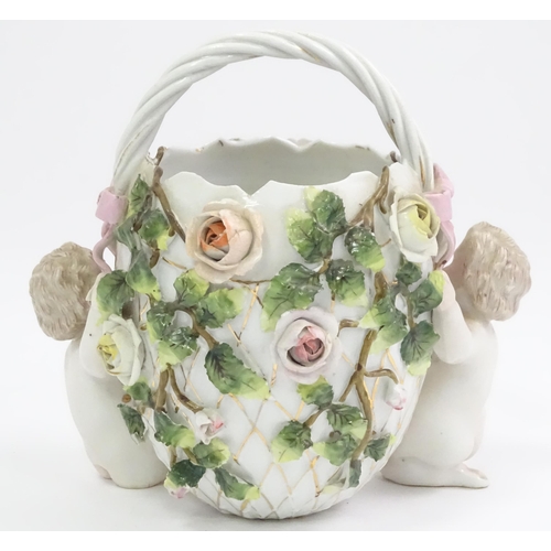 393 - A German porcelain basket with cherub and encrusted flower detail. Marked under with Sitzendorf styl... 
