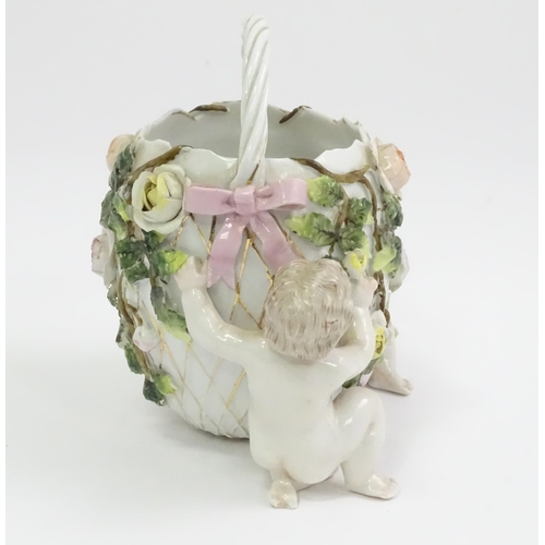 393 - A German porcelain basket with cherub and encrusted flower detail. Marked under with Sitzendorf styl... 