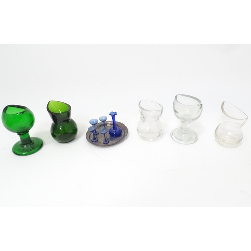 395 - A quantity of Victorian eyebaths to include green and clear glass examples. Together with a silver p... 
